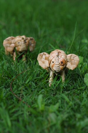 Elephant rattan handmade standing through tall grassの写真素材