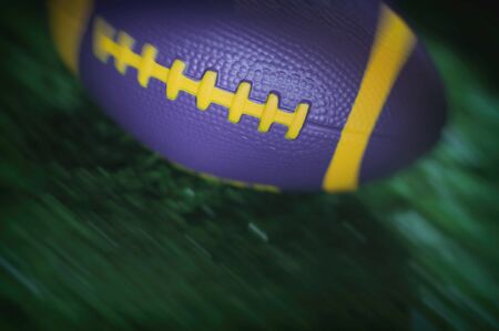 Healthiness concept and sport background idea, Close up of moving mini american football on the green grassの写真素材