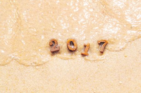 Wood number 2017 on beach background with soft wave idea, happy new year conceptの写真素材