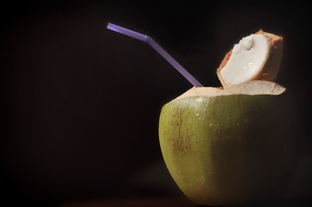 Coconut water drink on black background, tropical fruit conceptの写真素材