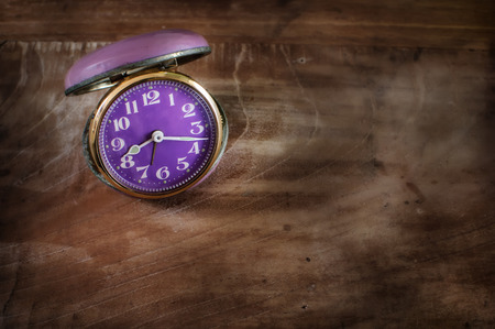 Retro alarm clock on wooden table, time management concept and moment of truth ideaの写真素材