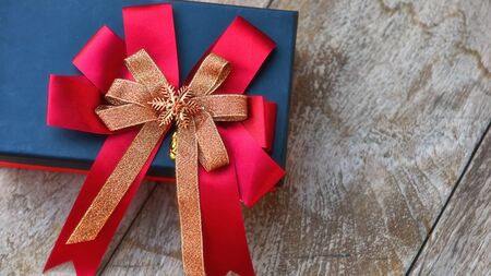 Gift box with ribbon on wooden background, celebration concept