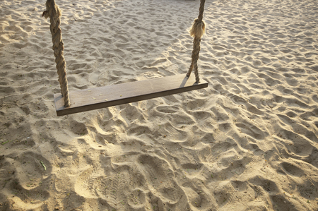 Close-up wooden swing on tropical beach background, happy summer holiday conceptの写真素材