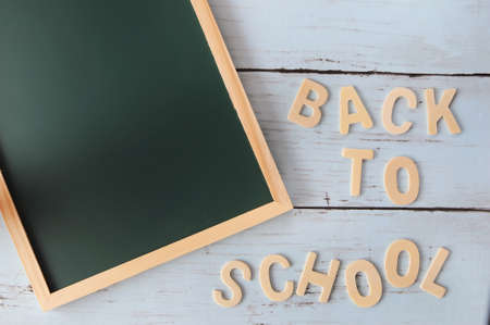 Word of back to school on wooden wall with blank blackboard, education concept and input text ideaの写真素材