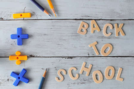 Word of back to school on wooden wall with colored pencil and math symbol, education concept and input text ideaの写真素材
