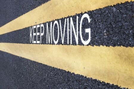 Keep moving word with yellow line marking on road surface, business success concept and challenge ideaの写真素材