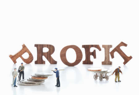 Wooden word of profit with miniature worker on white backgroundの写真素材