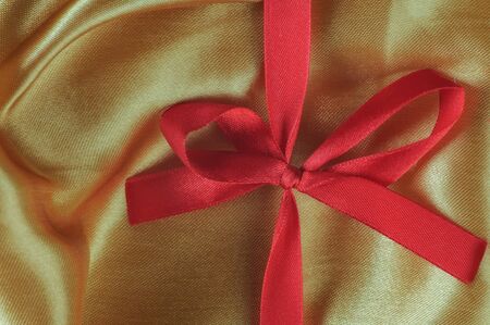 Closeup red ribbon on yellow fabric backgroundの写真素材
