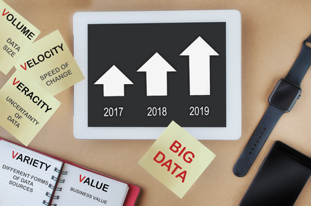 Big data concept on modern working desk with growth graph on computer tablet screen