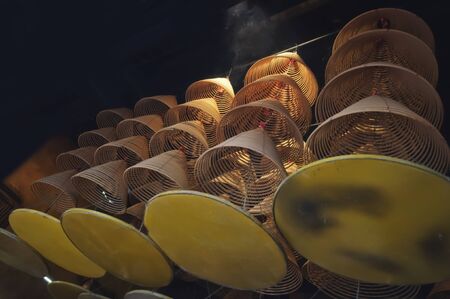 Burning incense coils at A-ma temple of Macau, handing under the temple roofの写真素材