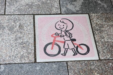 Sign child bike paint on tile on walkway in Kyoto, Japan