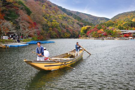 Kyoto, Japan - November 26, 2019: Delivery man riding boat at Hozu river in Autumn season at Arashiyama areaのeditorial素材
