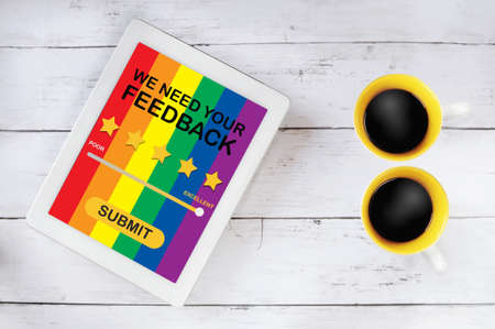 LGBT business rating application review on computer tablet with cup of coffee on table. Five stars...
