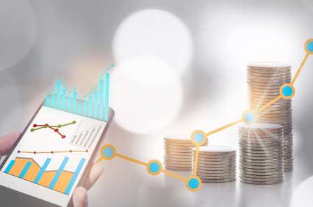 Financial technology application and return on investment on smart phone screen and stack of coins on abstract background. Fintech concept and economic recovery with growth ideaの写真素材