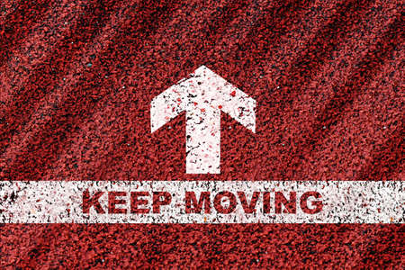 Keep moving word on starting line with arrow on red road background. Business go ahead concept and success ideaの写真素材
