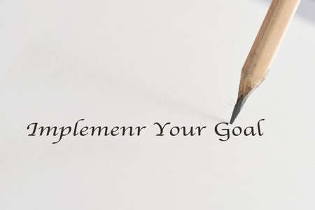 Implement your goal written on white paper with pencil. Future ahead concept and time for action...