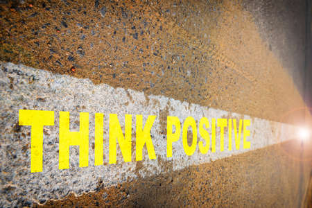 Think positive on asphalt road with sand and white marking line. Business challenge concept and success ideaの写真素材