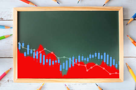 Financial depressing graph stock trading on chalkboard with coloured pencils on wooden. Economic crisis concept and business recession ideaの写真素材