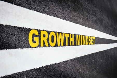 Growth mindset on asphalt road with marking lines for giving directions. Business success with future ahead concept. Self development to new skillsの写真素材