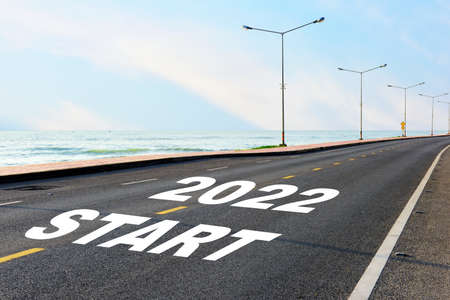 Start new year 2022 on asphalt road with marking line for given direction and sea landscape. Road to recovery concept and business success ideaの写真素材