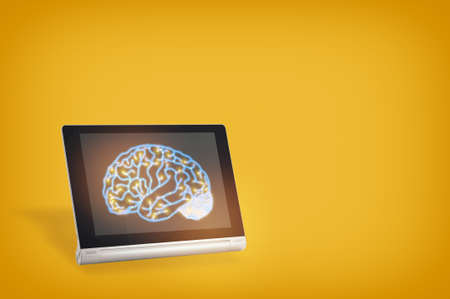 Growth mindset built business concept and machine learning idea. Brain on computer digital tablet on yellow backgroundの写真素材