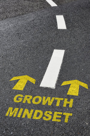 Growth mindset with yellow arrow marking on road surface with white marking line. Optimism empathy personality concept and motivation to success ideaの写真素材