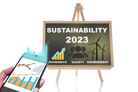 2023 sustainability on chalkboard and online financial technology or fintech on smartphone on white background. Economic recovery and making money concept with sustainable development ideaの写真素材
