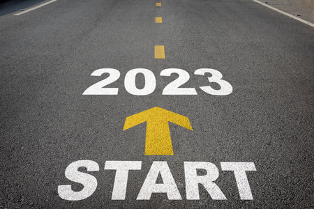 Start to 2023 written on the road background with yellow arrow. Business planning concept and new year beginning success ideaの写真素材