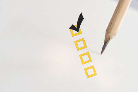 Check list box with  check mark on white paper with pencil.  Selection concept and success idea