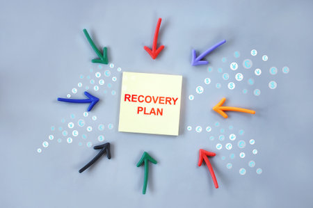 Recovery plan written on yellow sticky note with colorful arrow. Making money and saving concept and planning improvement ideaの写真素材