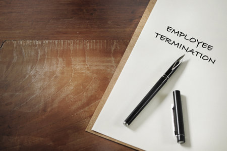 Employee termination words written on notebook on working desk. Economic recession concept and  unemployed ideaの写真素材