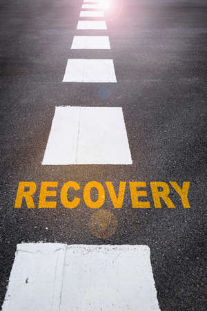 Recovery written on the road. Business success concept and challenge ideaの写真素材