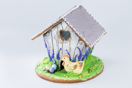 gingerbread house with chicken, colored eggs and flowersの写真素材