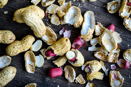 Healthy and diet food. Unpeeled peanuts on wooden rustic background. Top view, flat layの写真素材