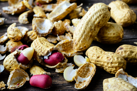 Healthy and diet food. Unpeeled peanuts on wooden rustic backgro
