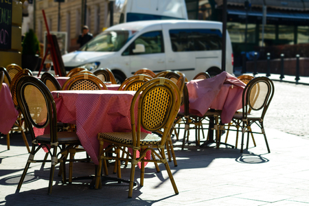 Street cafe or restaurant in the European city. Brown chairs and tables standing near an entrance in the cafeの写真素材