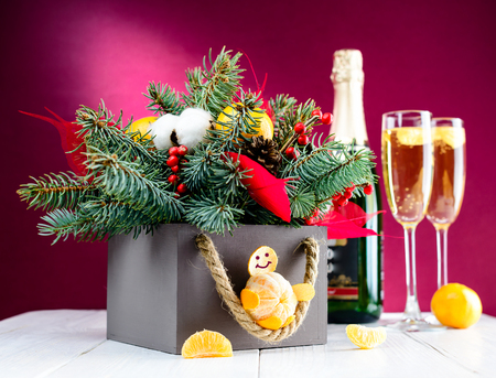 Glasses with champagne and Christmas decoration box against pinkの写真素材