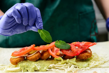 Process of preparing appetizing roll with falafel, vegetables anの写真素材