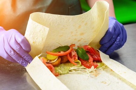 Process of preparing appetizing roll with falafel, vegetables anの写真素材