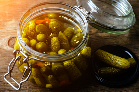 Glass jar with fresh low-salt pickled homemade cucumbers on woodの写真素材