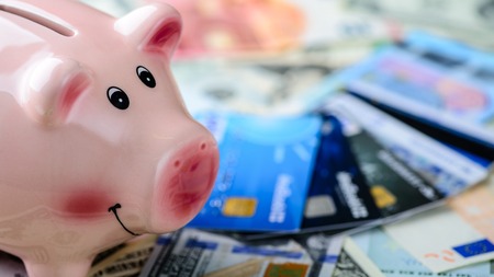 Dollar vs euro banknotes, piggy bank and credit cards as backgroの写真素材