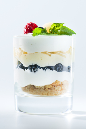 sweet Italian Tiramisu dessert in a glass with raspberries, blueの写真素材