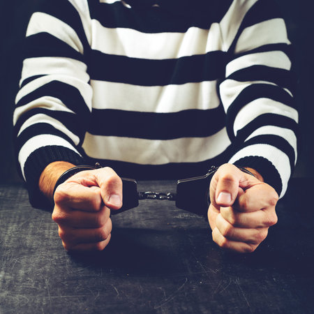 unidentified prisoner in handcuffs in prison stripped uniform si