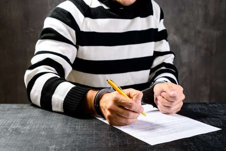 unidentified prisoner in prison stripped uniform sitting on theの写真素材