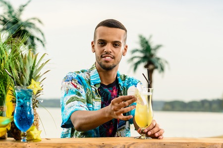Handsome Latin American bartender standing near the bar counter,の写真素材