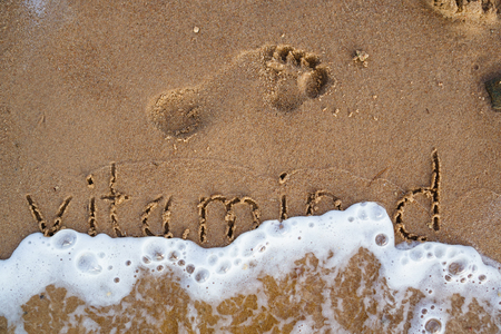 Vitamin D handwritten on sand beach with the wave of sea. Beachの写真素材