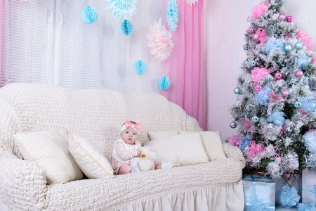 Portrait of charming baby girl dressed in pink clothes sitting o