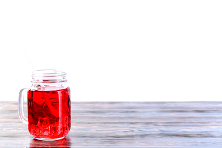 Wooden table top with one mason jar full of lemonade on light baの写真素材
