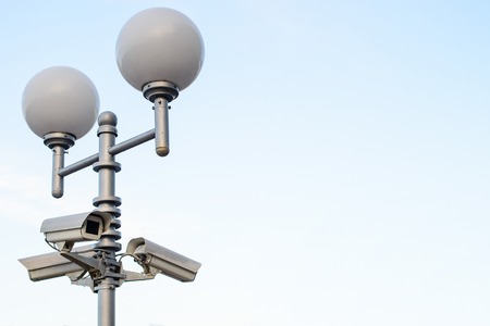 Public city video surveillance cameras and street lamps on the lの写真素材
