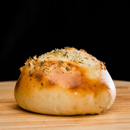 close-up of homemade mini pizza bun topped with cheese, garlic a